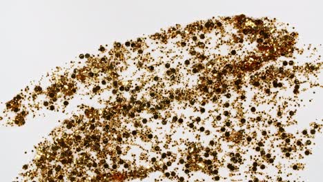 brushstrokes of gold paint brush applied isolated on a pink background. gold paint smear texture. shine, stars, sparkles. golden sparkling textured artistic illustration. smears of cosmetics.