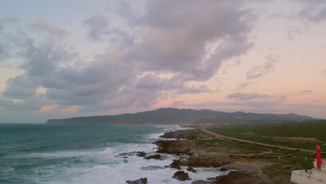 dramatic seashore stormy ocean crashing of wild shore under cloudy evening sky.