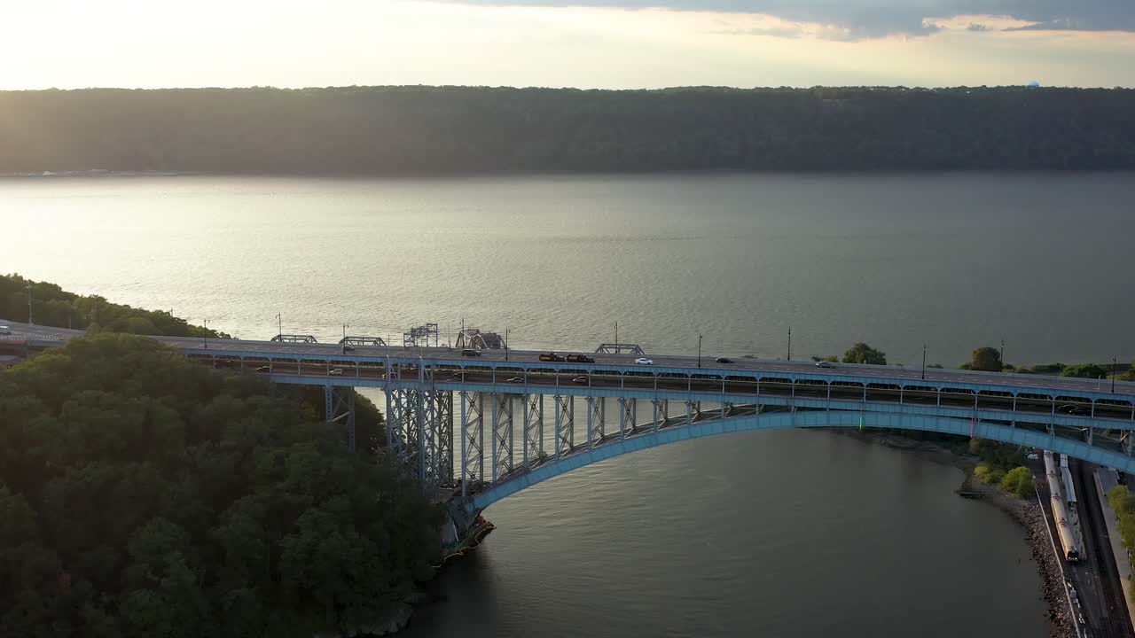 inclinación aérea hacia el puente henry hudson entre manhattan y el sur del bronx nyc, hermosa vista del río hudson en la distancia y los acantilados de empalizada de nueva jersey al atardecer