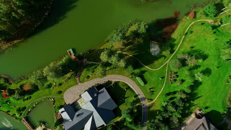 luxury real estate on coastline of small pond, aerial top down view