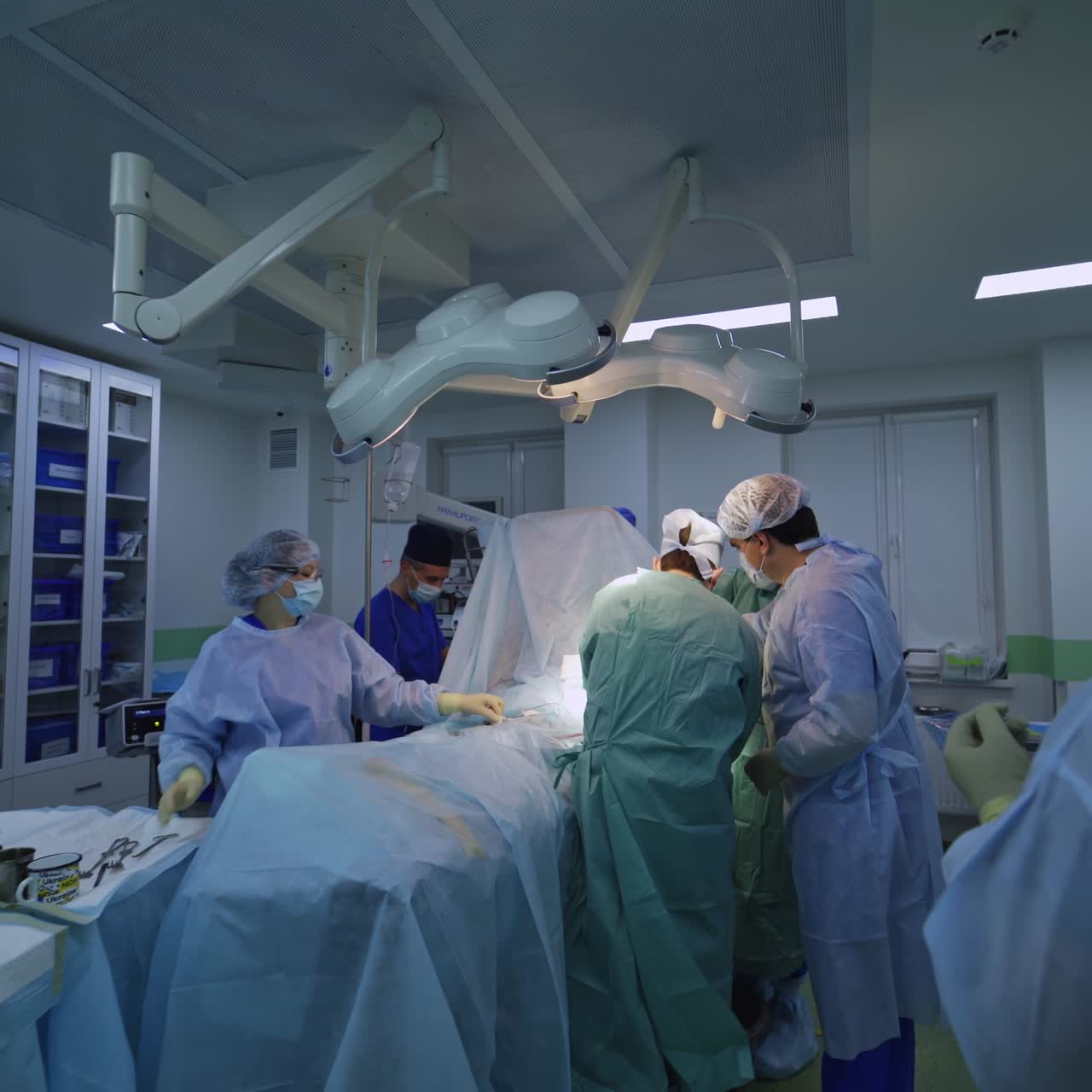 Big group of professional medic dealing with surgery. Gradual distancing from a place of operation