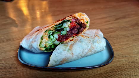 closeup shot toasted wrap with fresh cucumber pita bread, red beans paste inside