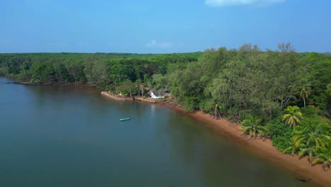 small fishing boat floating near tropical coast of koh mak island, thailand. spectacular aerial view flight descending drone