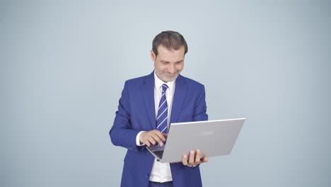el hombre de negocios satisfecho mira la computadora portátil y aprueba.