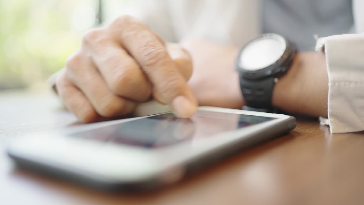 A young businessman wearing a surgical mask is taking a video conference with customers via a smart phone connected to the Internet.