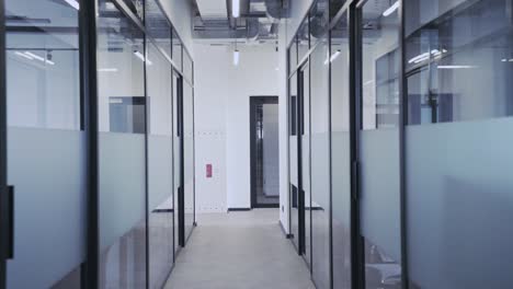 empty office corridor with glass walls and many doors, comfortable workplace