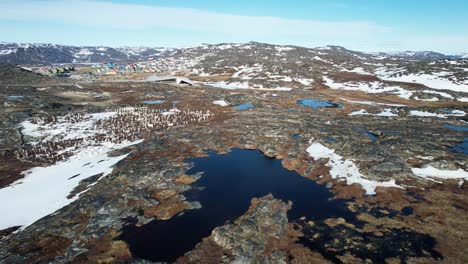 Cemetery-with-white-crosses-in-rocky-terrain-of-Greenland,-aerial-view