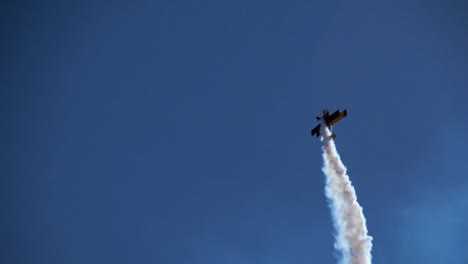 a biplane does a slow motion roll stunt during the biannual air show at hill afb utah with smoke trailing behind 1