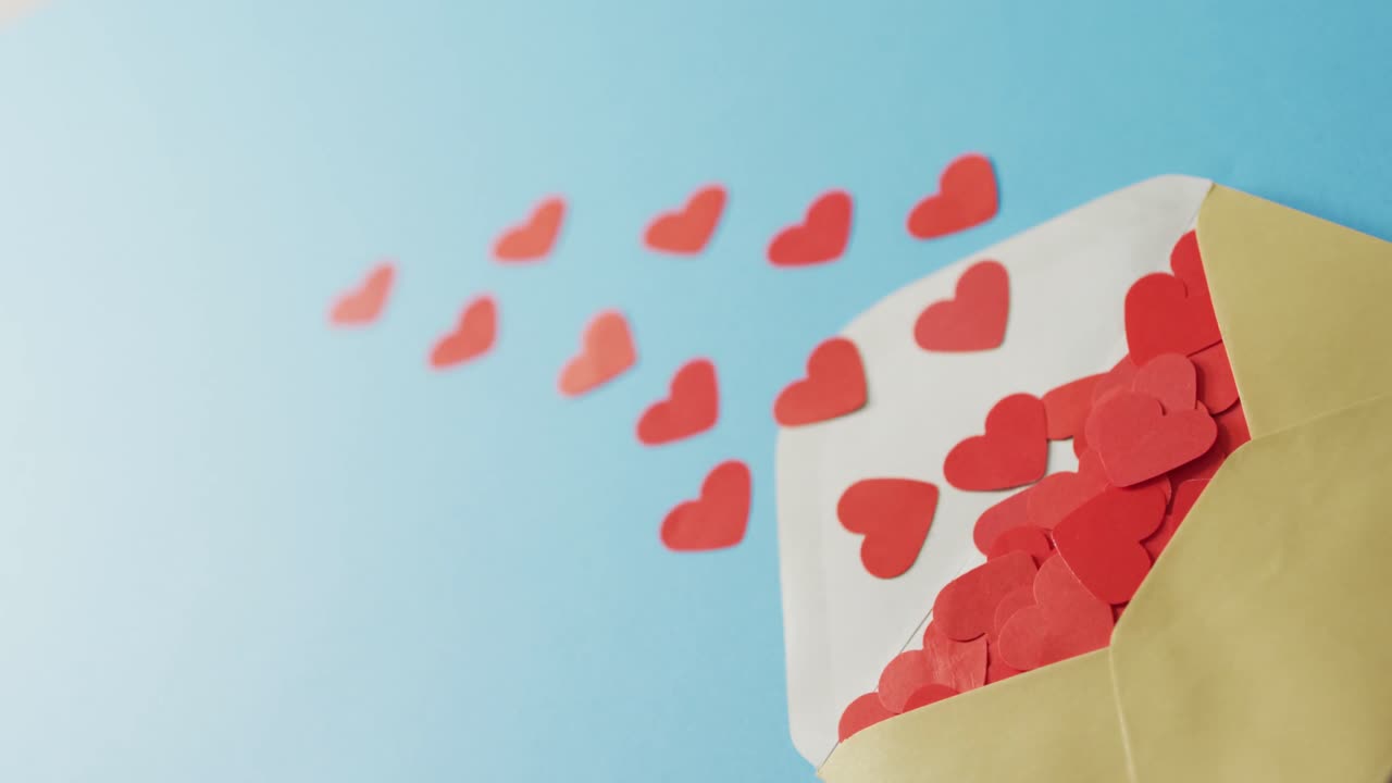 Envelope with paper hearts on blue background at valentine's day