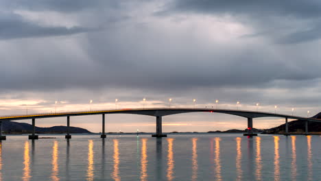 Luces-De-La-Calle-Del-Puente-Sommaroy-Iluminadas-Por-La-Noche-Reflejándose-En-El-Agua-En-Noruega