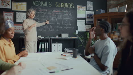grupo de estudiantes escuchando al maestro explicando la lección de gramática inglesa