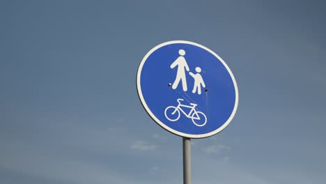 señal de pasarela para peatones y ciclistas contra el cielo azul, vista de cerca desde abajo. señal de senderos para bicicletas y peatones. señal de carretera peatones y cyclistas contra un fondo azul