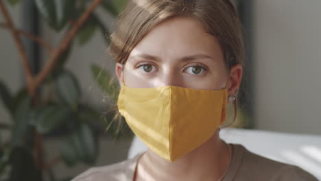 portrait of young woman in yellow mask at home