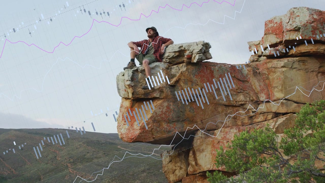 hiker sitting on ledge, shifting as graphs overlaying and growing across valley for data monitoring
