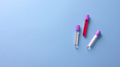 Close-up-of-blood-samples-on-blue-background-with-copy-space,-slow-motion