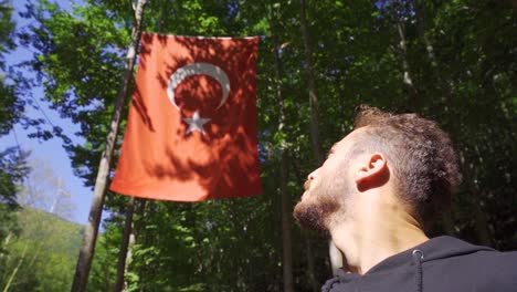 young muslim praying looking at turkish flag. slow motion.