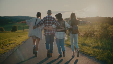 carefree friends with arm around walking on footpath