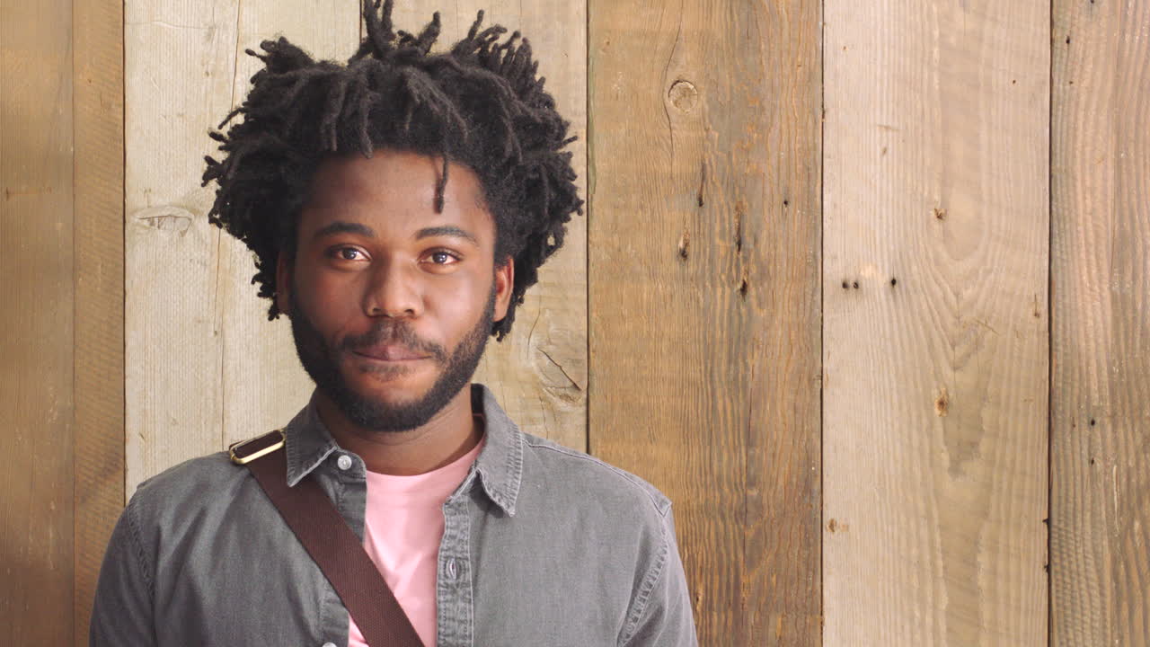 retrato de un feliz hipster de moda contra una madera