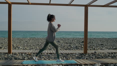 woman doing lunges on a beach