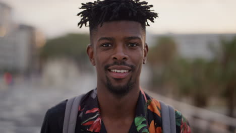 retrato feliz hombre afroamericano sonriente alegre atractivo turista negro disfrutando de las vacaciones de verano viaje buscando relajado peinado funky cámara lenta