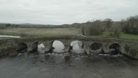 Car-Passing-Across-An-Old-Bridge-Over-The-Slane-River-In-Wexford,-Ireland