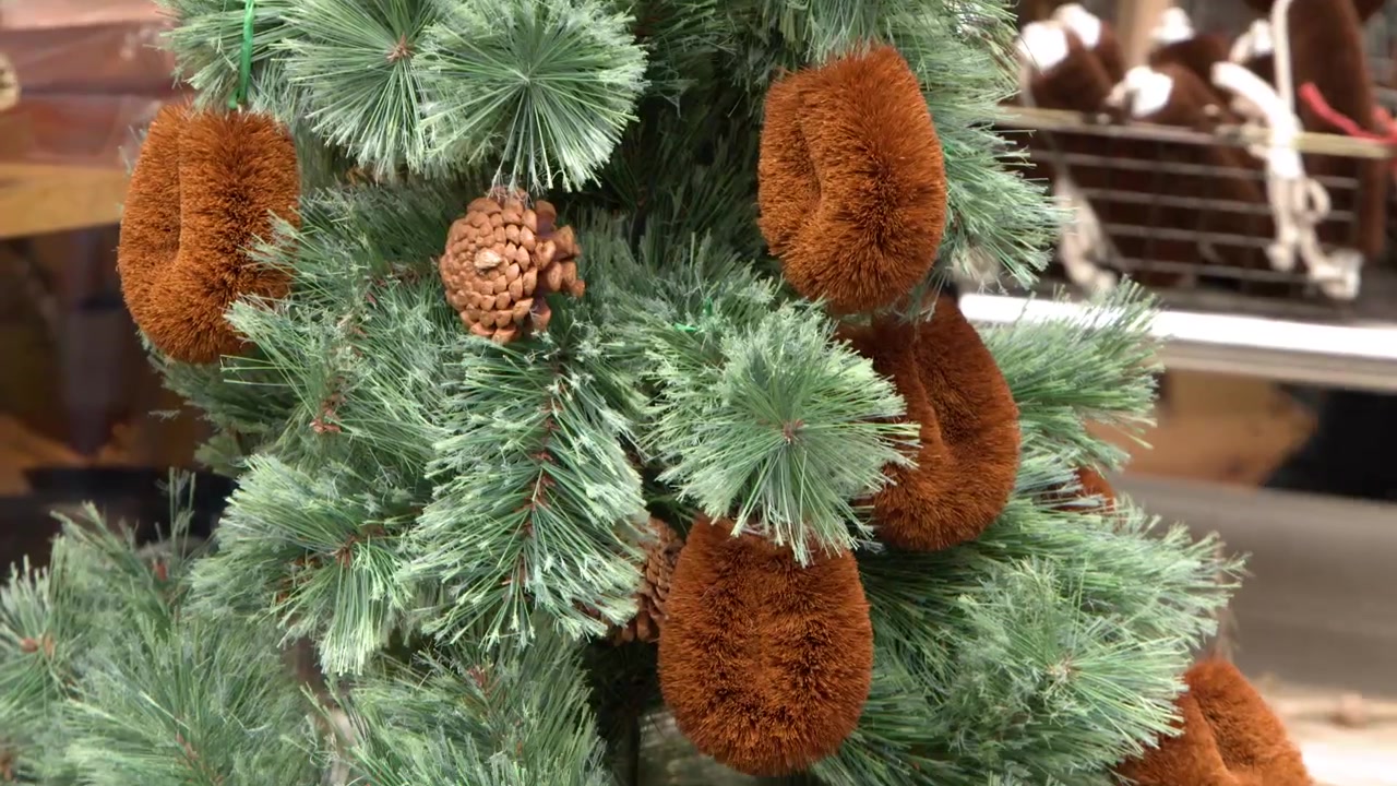 La telecamera inquadra verso il basso un albero festivo decorato con tradizionali spazzole tawashi giapponesi a Tokyo.