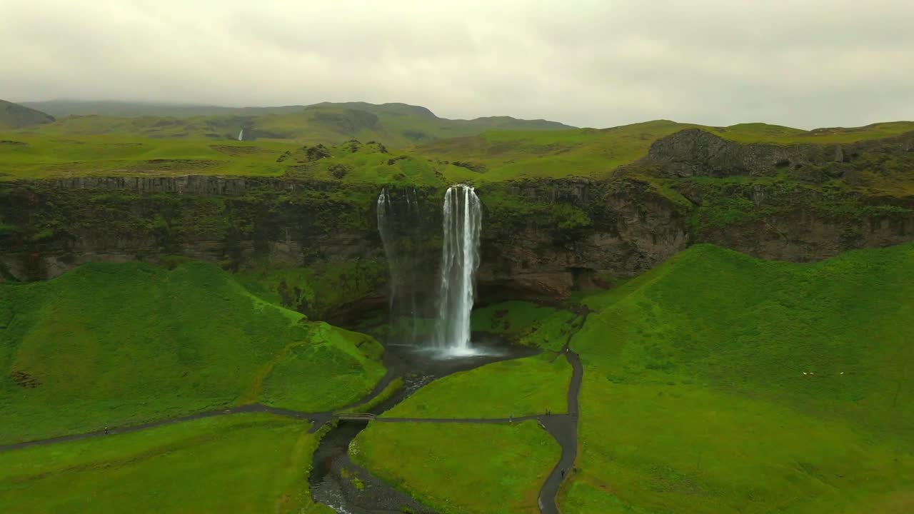 Experience the breathtaking beauty of Seljalandsfoss from above, where cascading waterfalls meet lush greenery in a stunning display of nature’s power.