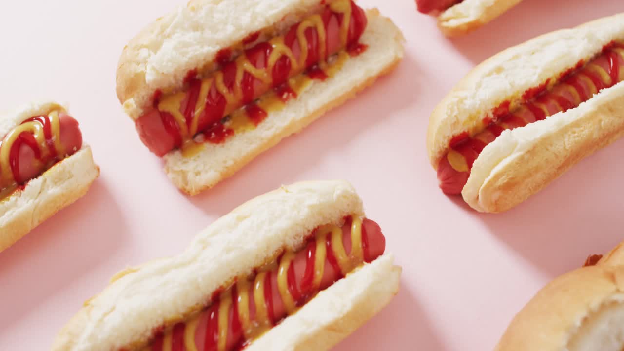 분홍색 표면 에 겨자 와 케치업 이 들어 있는 핫도그 의 비디오