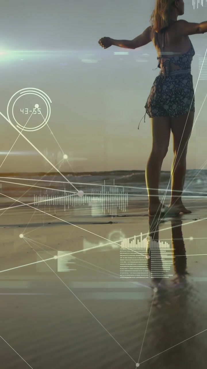 Vertical video: Woman walking wet sand, camera panning while HUD lines over scene linking tech data