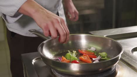 chef preparando verduras en una sartén