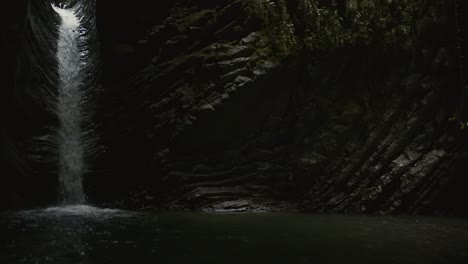 dark waterfall in a rocky canyon