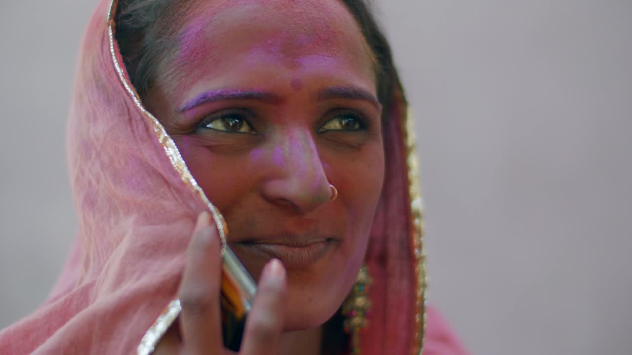 Indian women close-up of face smeared with bright Holi colors