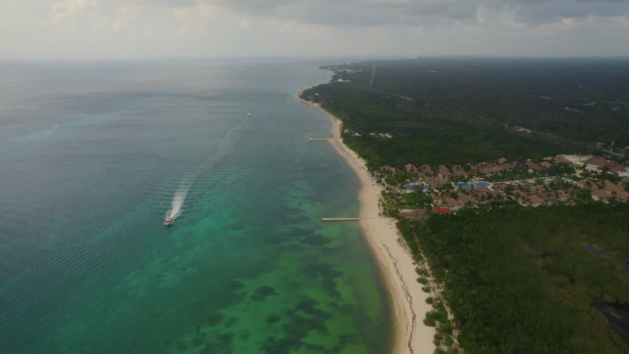 vista aérea del paisaje de la playa en isla cozumel, méxico con un barco navegando cerca de la orilla