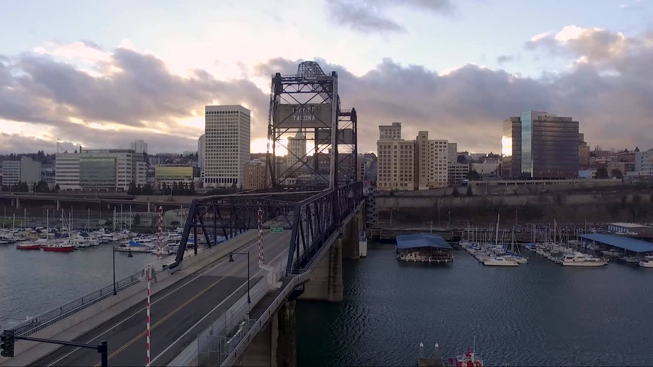 Aerial, rising, drone shot overlooking the 11th St Bridge, on the Thea Foss Waterway, at sunset, in Tacoma WA, USA