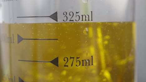 measuring liquid in a transparent plastic measuring cup