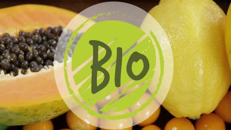 animation of bio text banner against close up of variety of fruits on wooden table