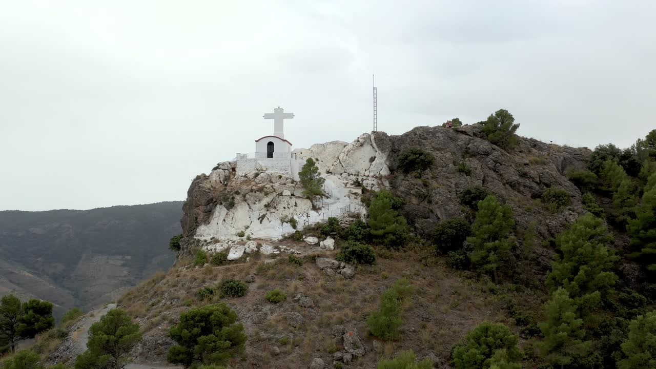 스페인의 작은 흰색 교회가 있는 바위산 정상의 관광객, 낮은 시차 드론