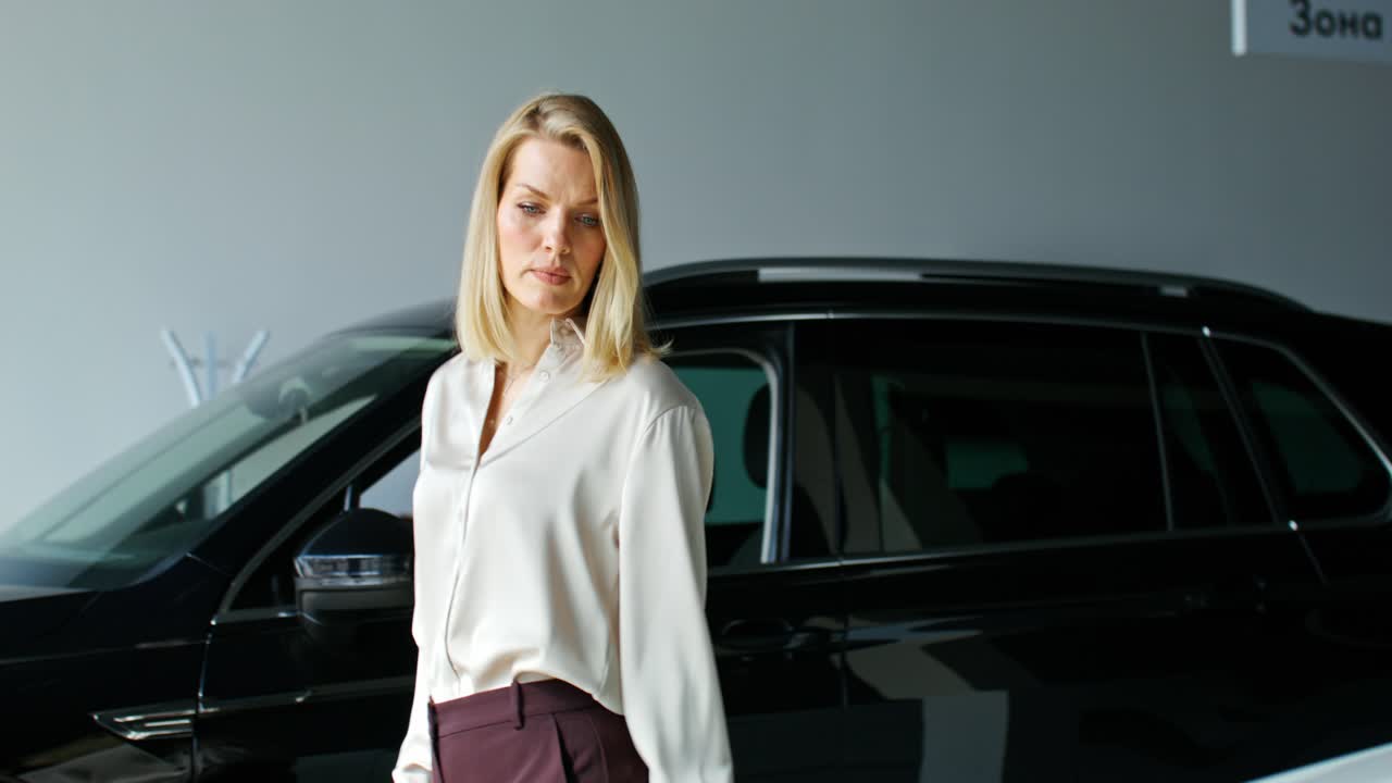 mujer viendo coches en una sala de exposiciones