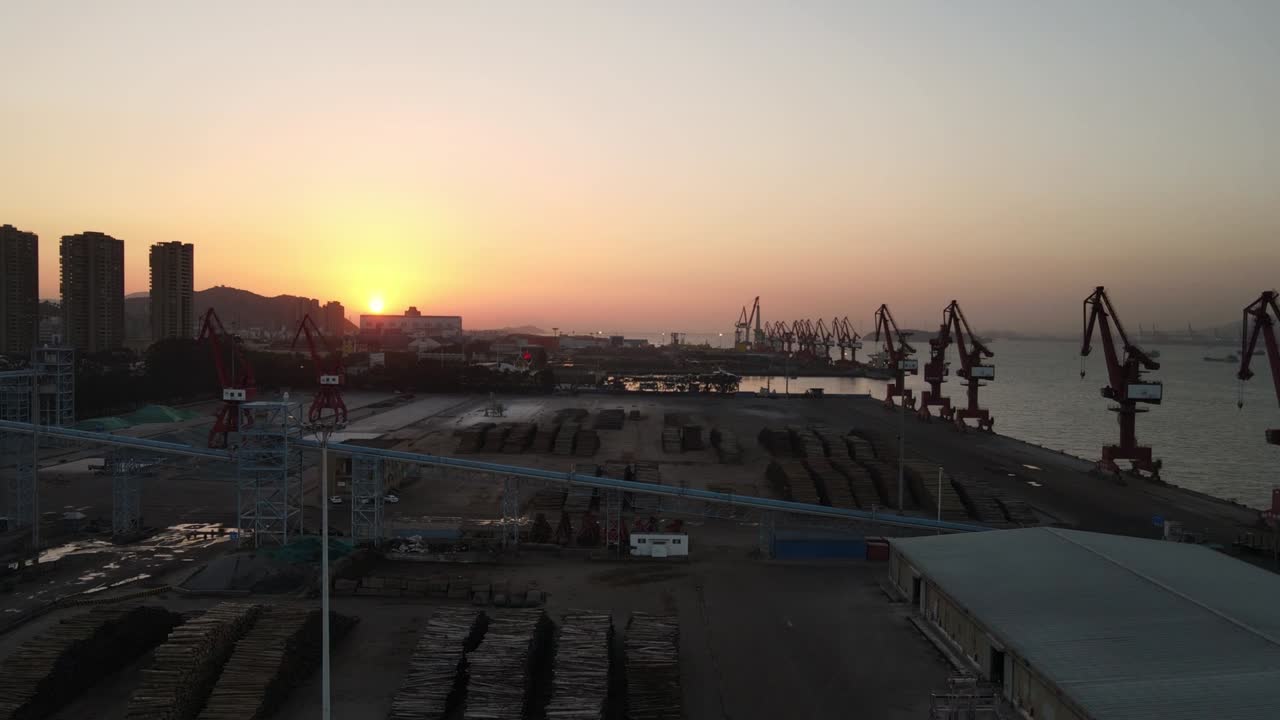 el video aéreo de la puesta de sol muestra la grúa y el contenedor del muelle desde el ángulo de vista superior