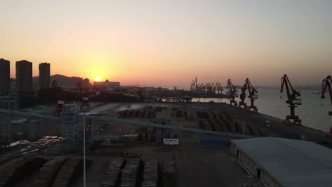 the aerial video of sunset shows the crane and container of the wharf from the top view angle