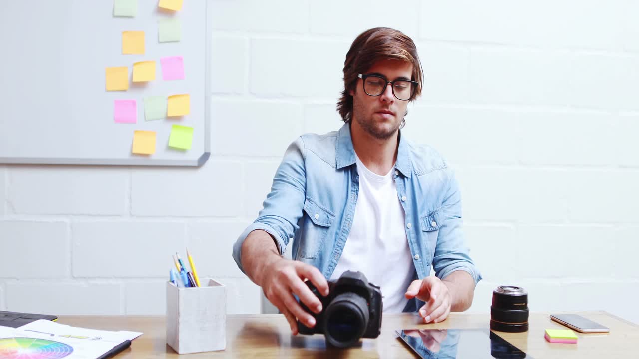 Man checking photos in camera and using digital tablet