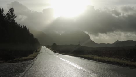 slow motion: road trip on a wet street through the scottish highlands