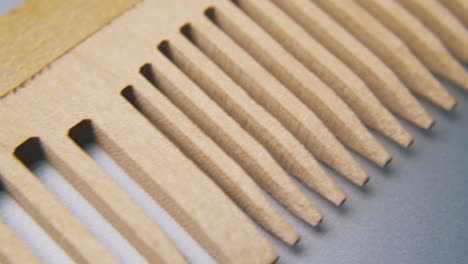 motion along handmade wooden comb lying on grey surface