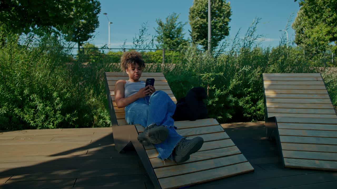 Femme se détendant à l’extérieur avec son téléphone portable