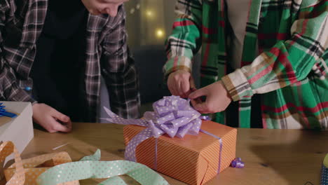 two people wrapping a gift together