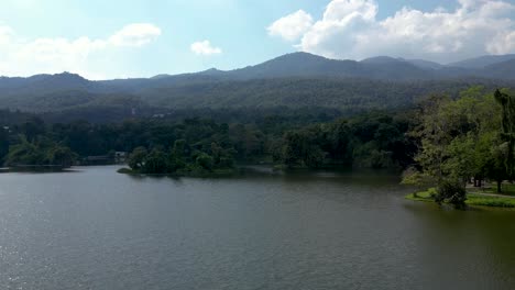 Slow-rising-aerial-drone-over-lake-with-mountains-in-distance