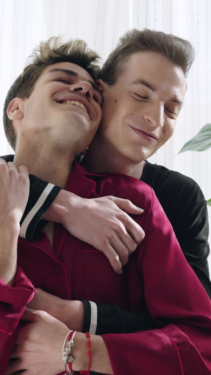 Felice giovane coppia gay che si abbraccia e sorride teneramente