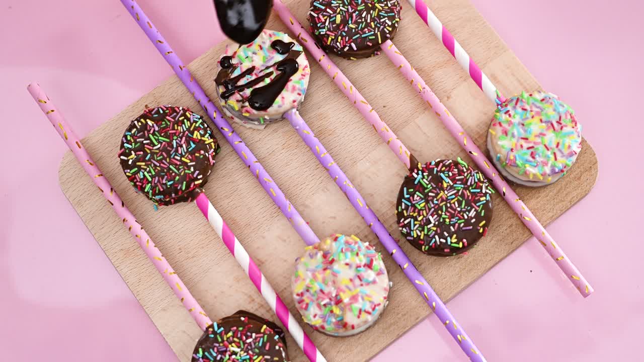 decorar deliciosos pasteles dulces en una tabla de madera con chocolate negro derretido