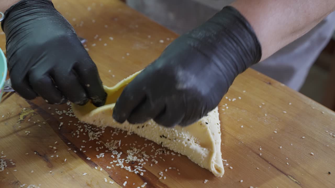un chef de pastelería dando forma a un pastel tradicional de flaouna para la pascua