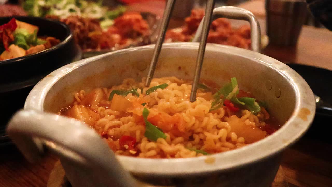 palillos para comer levantando el ramen de una olla